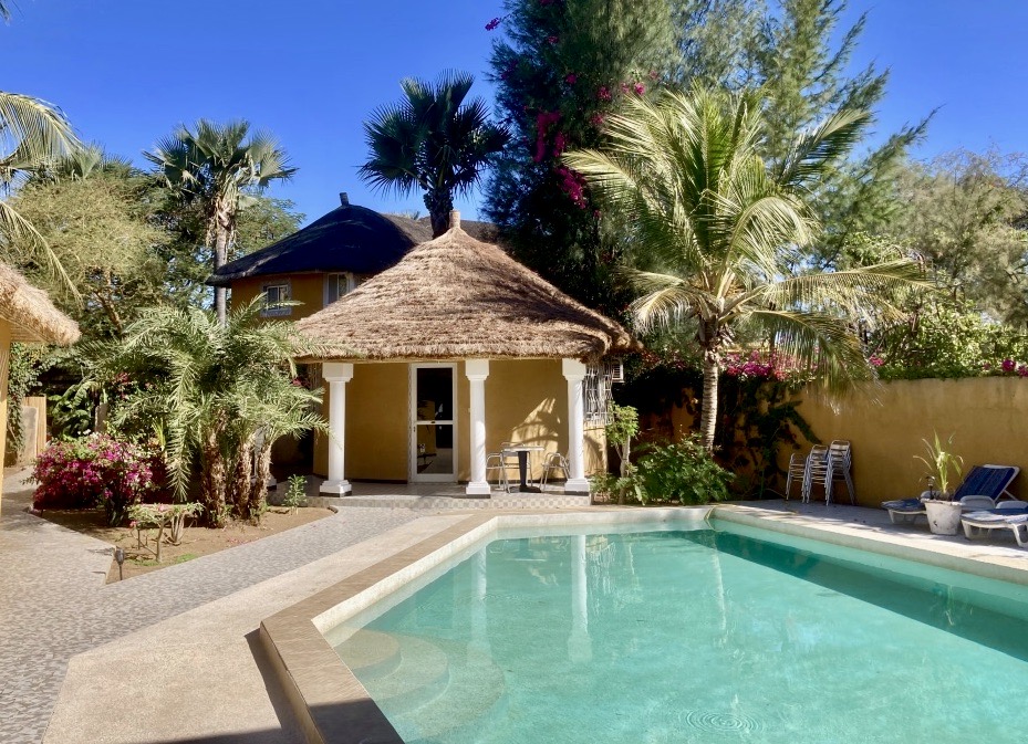 Piscine de la villa entourée de palmiers et de bungalows