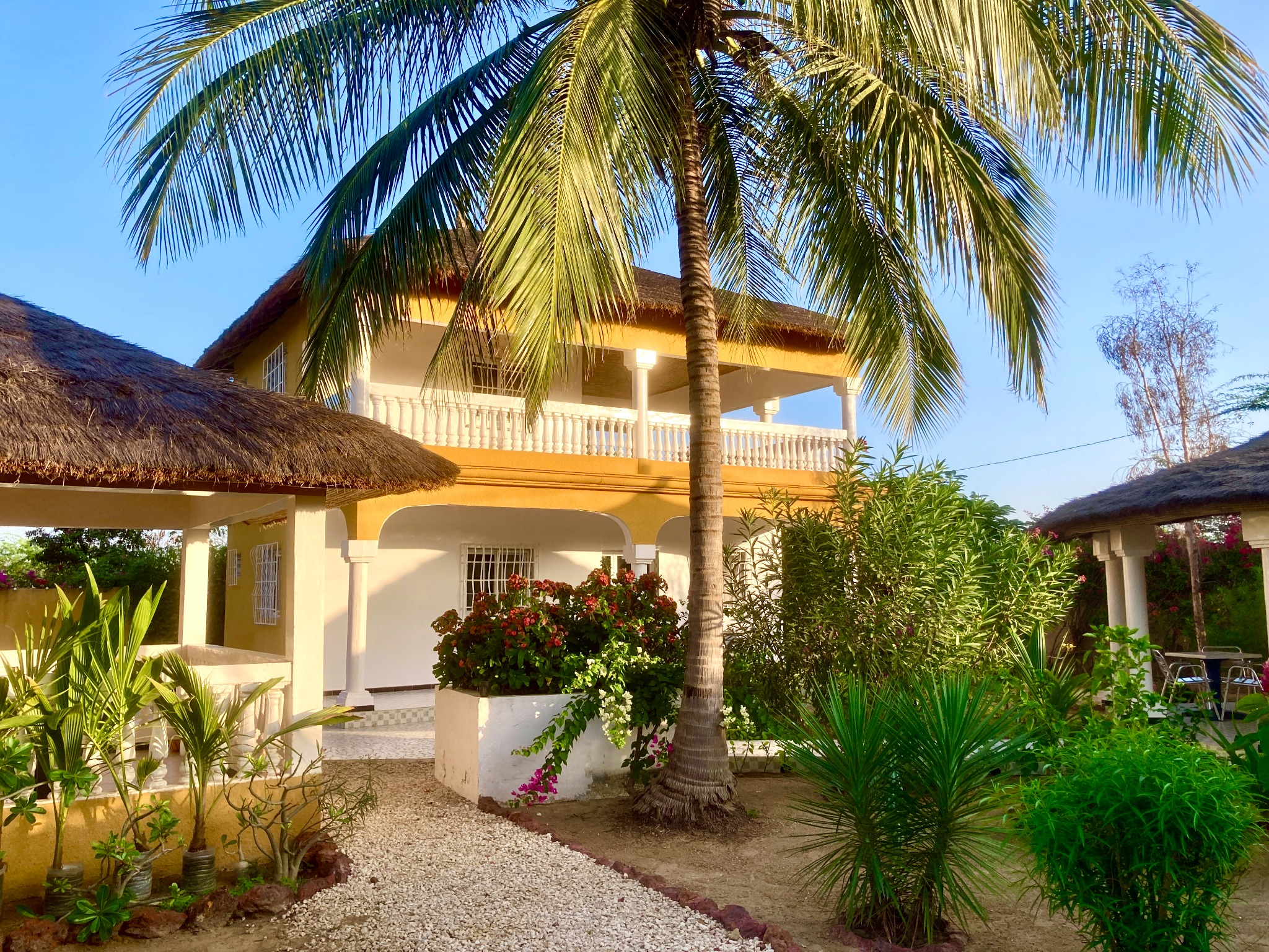 Façade de la villa, jardin et palmiers