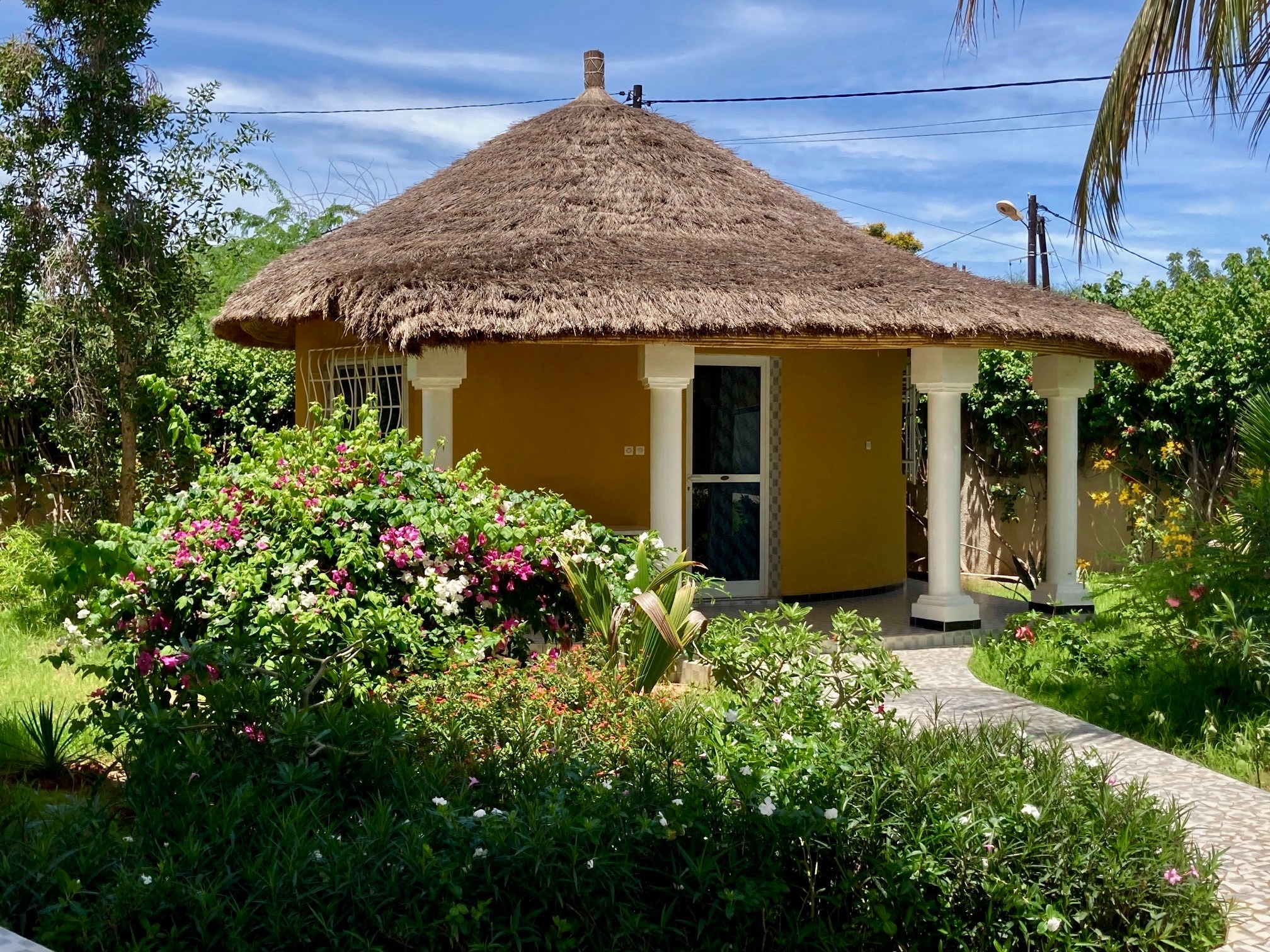 Bungalow au toit de chaume entouré de fleurs