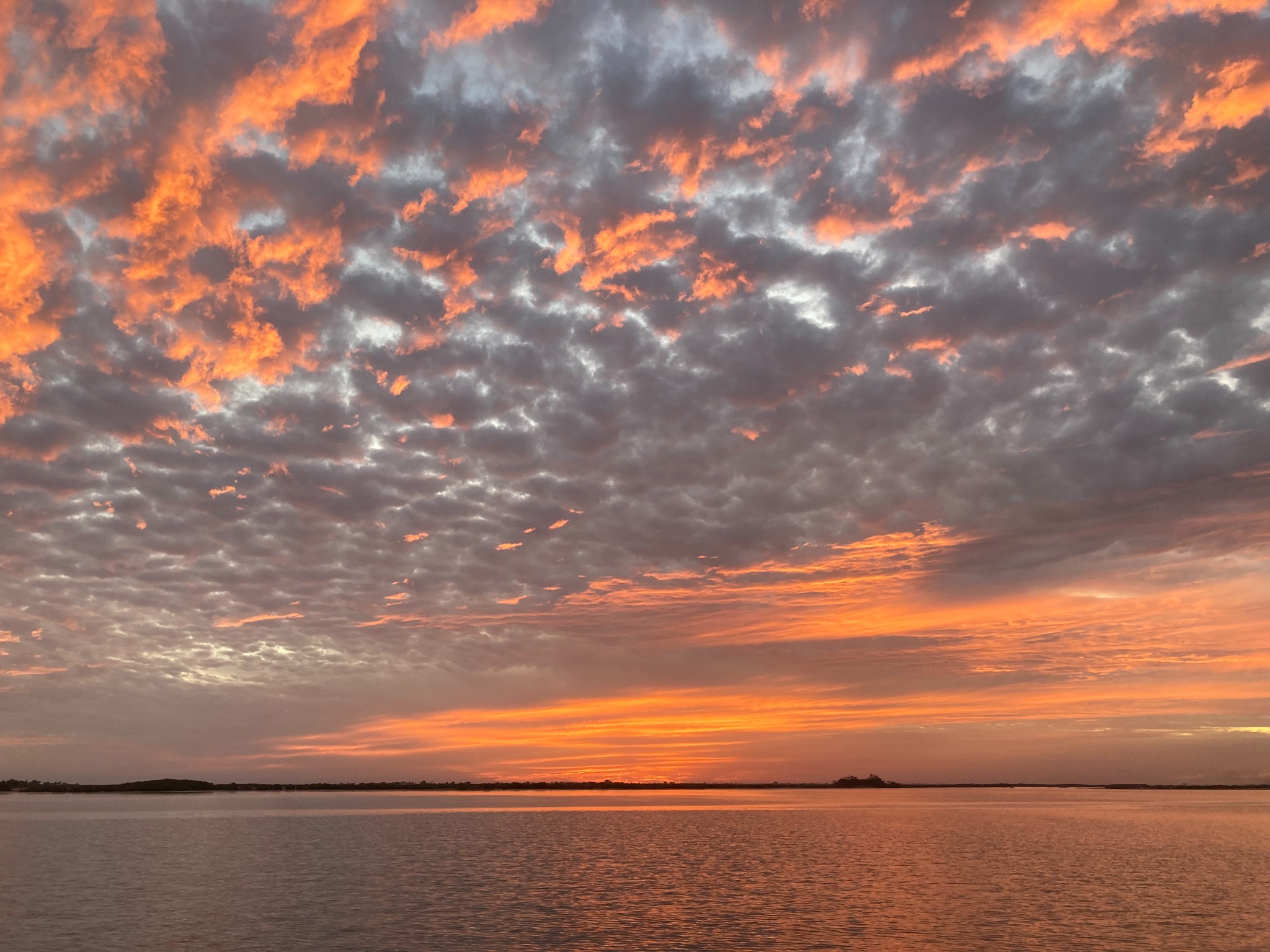 Nuages colorés au-dessus de l’eau au coucher du soleil